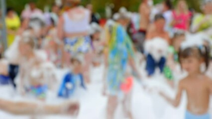 Crowd of children and adults have fun in white foam at a foamy party in the hot summer at an amusement park. Children catch foam and soap bubbles with their hands at a summer holiday - Powered by Adobe