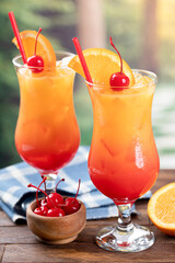 Tequila sunrise cocktail with orange slice and cherry