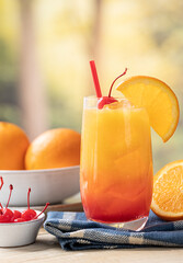 Tequila sunrise cocktail with orange slice and cherry