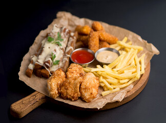 Cheese, croutons, meat and french fries - wide selection of beer snacks with different sauces on parchment top
