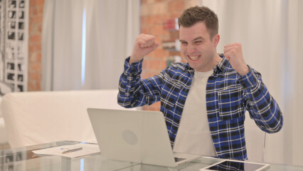 Excited Young Casual Man Celebrating Success on Laptop