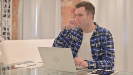 Young Casual Man Coughing Working on Laptop