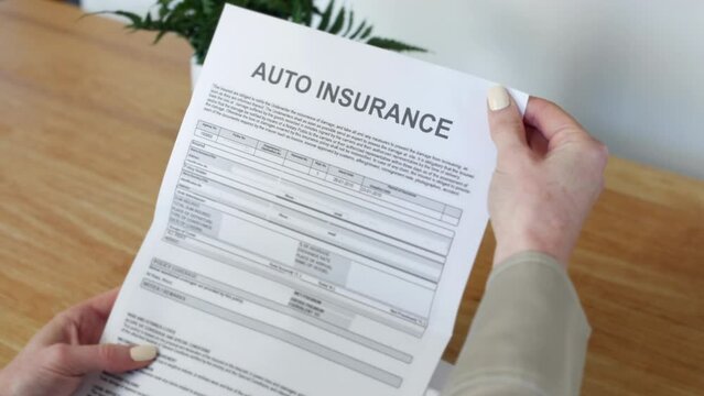 A woman opening an Auto Insurance Document letter outlining her policy and cover details