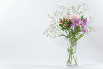 白い背景のガラスの花瓶に飾られた春の花