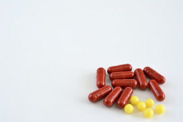 Red pills with yellow pills on a white background isolated, copy space   