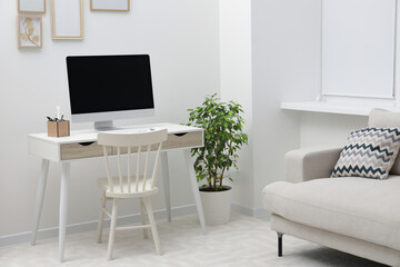 Spacious workspace with desk, chair, computer and potted plants at home