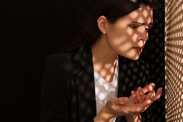 Woman talking to priest during confession near wooden partition in booth, space for text