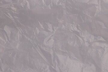 Crumpled transparent plastic bag as background, top view