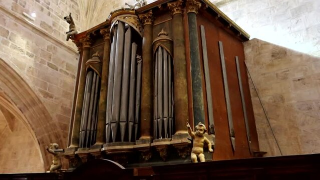Panning shot of a large organ with angels within the Santa Maria La Real Church, Burgos