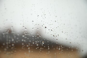 Naklejka na ściany i meble Window glass with water drops, closeup. Rainy weather