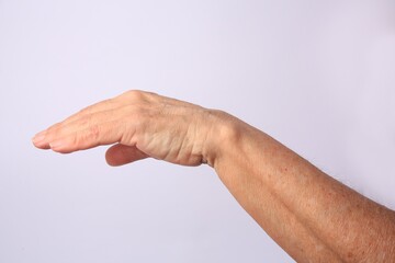 Closeup view of older woman's hand on white background