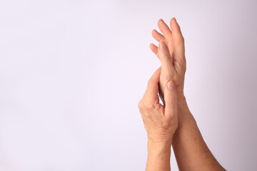 Closeup view of older woman's hands on white background. Space for text