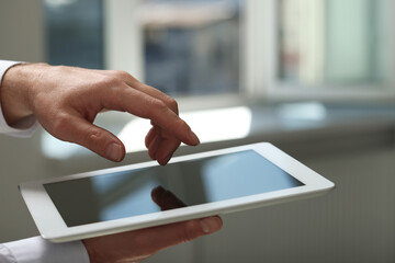 Closeup view of man using new tablet indoors