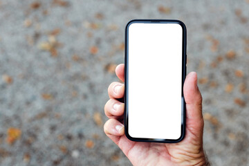 Fototapeta na wymiar Mockup smartphone in male hand. Blank white touchscreen held by the adult male outdoor. Technology and communication concept.