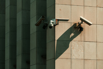 Old worn surveillance security cameras mounted on building wall