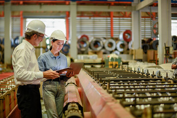 woman engineer assistant secretary in helmet inspection check control heavy machine construction installation in industrial factory with boss manager. Boss and partnership check maintenance factory