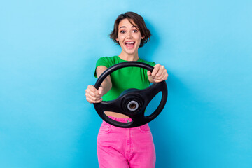 Photo of crazy young woman bob brown hair wear green t-shirt pink trousers steering wheel sports...