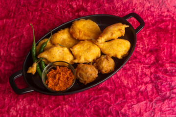 Indian Tea time snacks in group includes Veg Samosa, Kachori/kachaudi, aloo bonda, khaman dhokla, bread, onion,chilli and moong pakora/pakoda/bhaji/bhajji/Bhajiya/bajji with sauces, selective focus