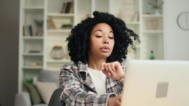 Sad african american woman student or freelancer with lack of new ideas or creative block typing and deleting text on laptop computer at home Worried female changing her mind every few seconds indoors