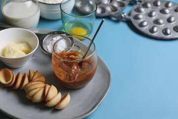 Baking mold and ingredients for walnut shaped cookies on light blue table. Space for text