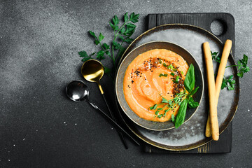 Carrot cream soup with basil and cream. In a bowl. Healthy food concept. Close up.