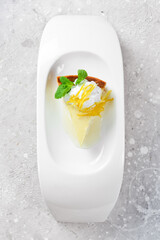 Dessert. Cheesecake with ice cream and honey. On a white plate. On a gray stone background. Restaurant menu.