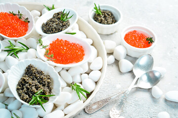 Macro photo. Red and black caviar in a bowl. On a gray concrete photo. Premium quality caviar.