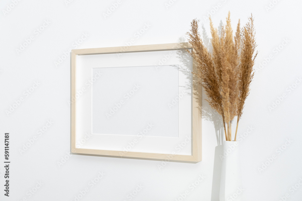 Wall mural wooden artwork frame mockup on white wall with dry grass decoration, blank mockup with copy space