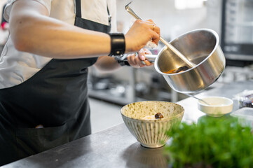 woman chef cooking seafood soup on restaurant kitchen