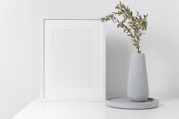 Blank portrait frame mockup in white room interior with natural botanical decor, white frame mock up