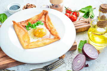 breakfast Scrambled eggs with pancakes and vegetables. On a white plate. On a gray stone background. Restaurant menu.