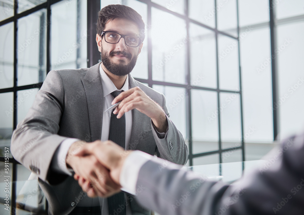 Wall mural Handshake of two businessmen who enters into the contract to develop a new software to improve business service at a company.