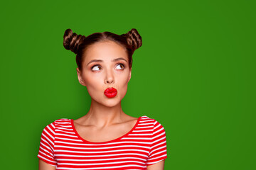 Attractive young girl with nice make up wearing striped tshirt puffed up her lips and looked up isolated on bright red background with copy space