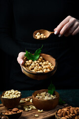 A bowl of hazelnuts in the hands of a woman. Healthy high-calorie vegan food concept. Close up.