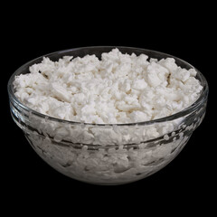 Cottage cheese in glass bowl isolated on black background. Side view of Acidic cultured curd