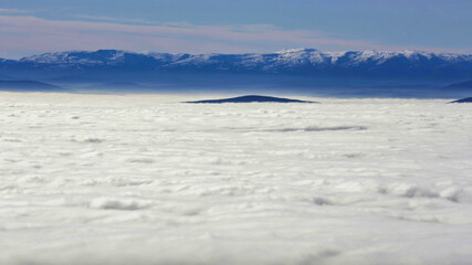 a snowy mountain behind the clouds