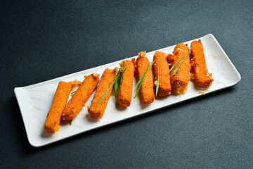 Grilled cheese on a plate. Barbecue menu. On a dark background, close-up.