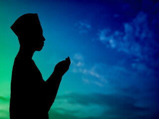 silhouette concept of muslim man praying to allah on hill. with a beautiful natural sunset panorama. focus on people