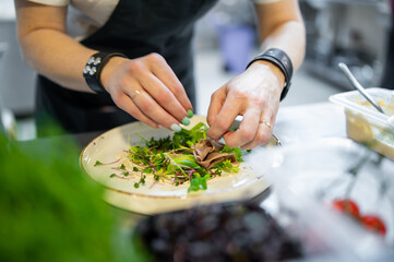 Chef cooking Beef tongue salad with fresh vegetables on restaurant kitchen