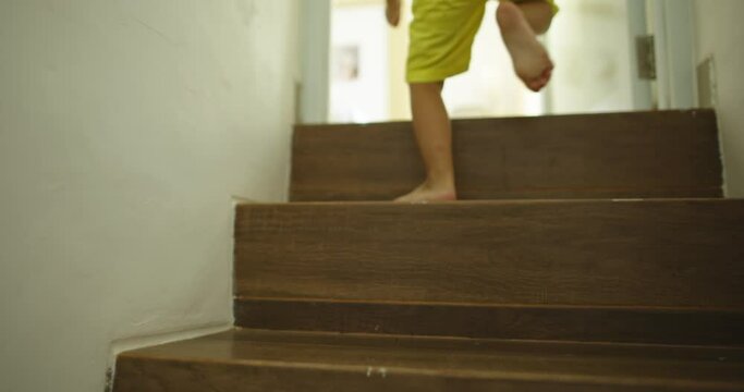 Boy runs up the stairs and jumps on the bed with smile and laughter