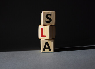 SLA - Service Level Agreement. Wooden cubes with word SLA. Beautiful grey background. Business and...