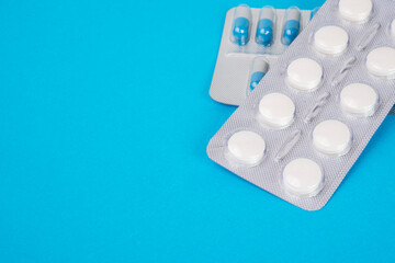 Pills in blister on blue background with space for text