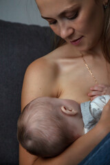 Close up cute mother breastfeeding newborn baby sitting on sofa at home, crop image. Woman care mum nursing baby in room, caring newborn kid. Concept of motherhood, maternity. Copy ad text space