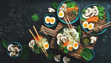 Fototapeta na wymiar Set of Japanese dishes with noodles, mushrooms, egg and microgreens. Udon and soba noodles. Food banner. Top view.