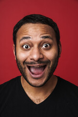 Fototapeta premium Positive indian guy screaming isolated over red background