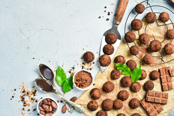 Preparation of Chocolate truffles and pralines on a light background. Top view. Space for text.