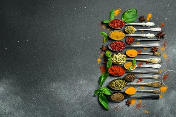 Fototapeten Set of spices and herbs in vintage spoons. Colorful various spices for cooking. On a black slate background. © Yaruniv-Studio