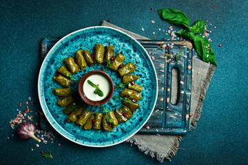 Traditional delicious Turkish foods: dolma (sarma) stuffed grape leaves rice. Close up. On a dark background.
