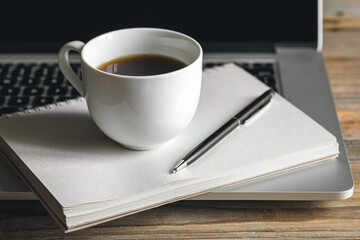 Cup of coffee, notepad and laptop, office work concept.