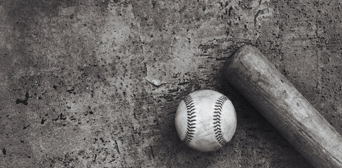 Old rough and rugged vintage style baseball banner background with ball by wooden bat, copy space for sport.